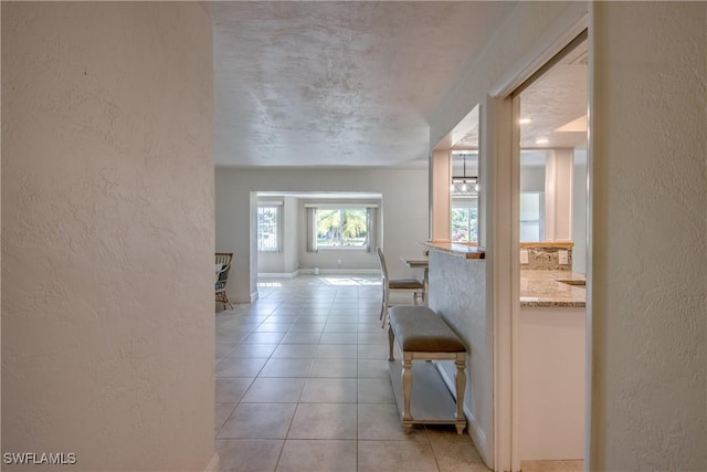 5549 Westwind Ln, Fort Myers, FL 33919 - hallway with a textured wall and light tile patterned floors
