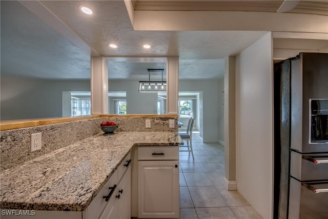 5549 Westwind Ln, Fort Myers, FL 33919 - kitchen featuring stainless steel fridge with ice dispenser, light tile patterned floors, white cabinets, light stone counters, and recessed lighting