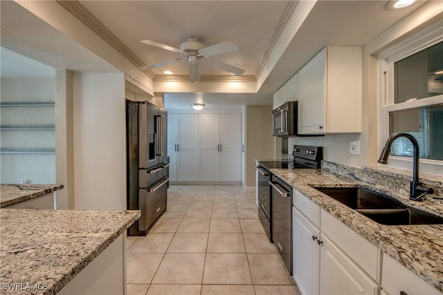 5549 Westwind Ln, Fort Myers, FL 33919 - kitchen with stainless steel appliances, crown molding, a raised ceiling, a ceiling fan, and white cabinetry