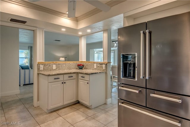 5549 Westwind Ln, Fort Myers, FL 33919 - kitchen with high end refrigerator, ornamental molding, light tile patterned flooring, white cabinetry, and light stone counters