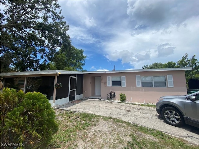 4920 Cortez Cir, Naples, FL 34112 - view of front facade with a sunroom and stucco siding