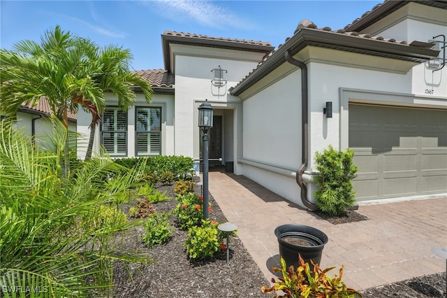 17467 Caravita Ln, Fort Myers, FL 33913 - doorway to property featuring a tile roof, stucco siding, and a garage
