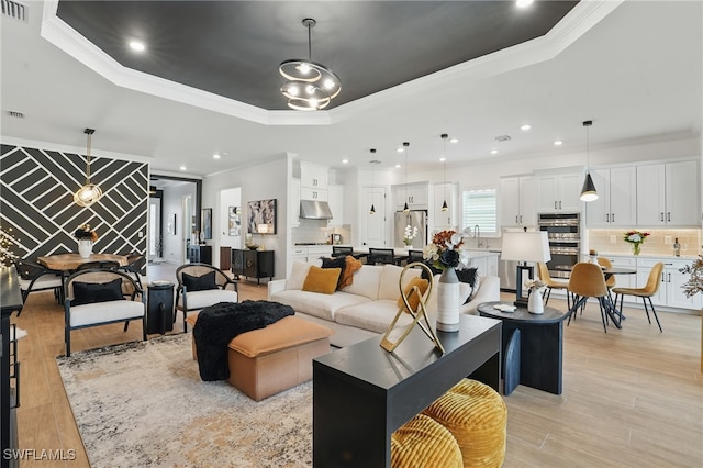 17467 Caravita Ln, Fort Myers, FL 33913 - living area featuring a tray ceiling, ornamental molding, light wood-style floors, and recessed lighting