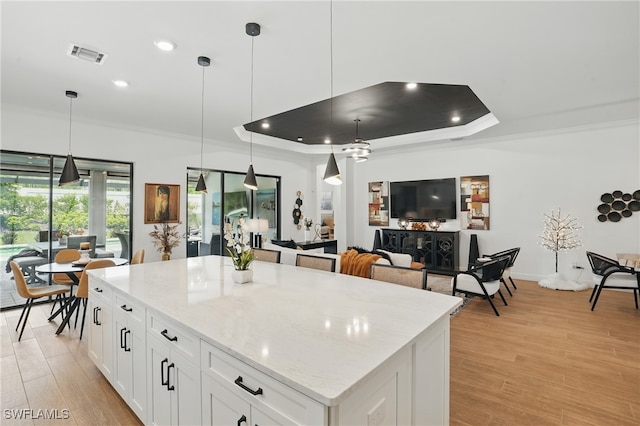 17467 Caravita Ln, Fort Myers, FL 33913 - kitchen with ornamental molding, a raised ceiling, recessed lighting, white cabinets, and pendant lighting