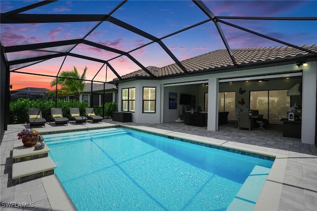 17467 Caravita Ln, Fort Myers, FL 33913 - pool at dusk with an outdoor pool, a patio area, outdoor lounge area, and glass enclosure