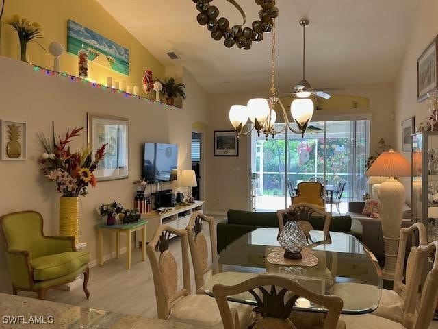 8187 Ibis Cove Cir Unit A113, Naples, FL 34119 - dining space with lofted ceiling, plenty of natural light, a chandelier, light carpet, and ceiling fan