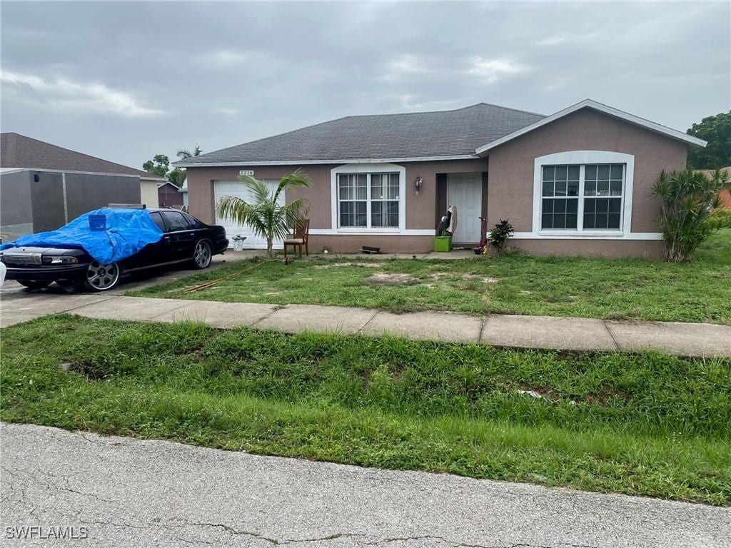1116 Bent Creek Loop, Fort Myers, FL 33916 - ranch-style home featuring an attached garage, stucco siding, a shingled roof, driveway, and a front yard