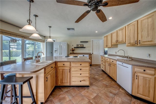 4180 Prestwick Ct, North Fort Myers, FL 33903 - kitchen featuring white appliances, light brown cabinetry, a center island, a ceiling fan, and a kitchen bar