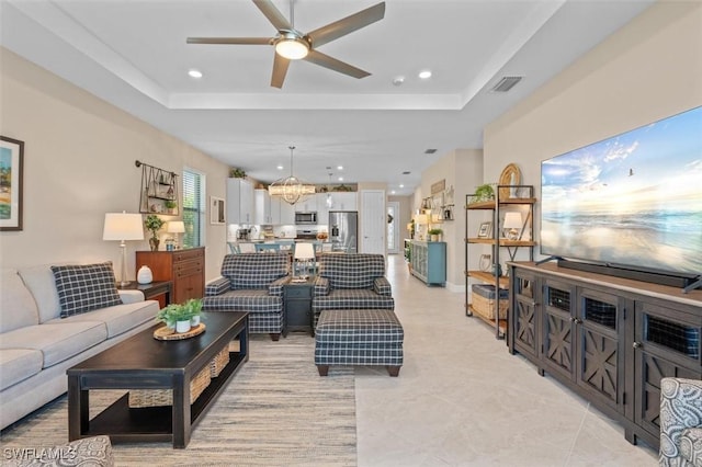 4012 E Hampton Cir, Alva, FL 33920 - living room with a tray ceiling, a ceiling fan, recessed lighting, light tile patterned flooring, and a chandelier