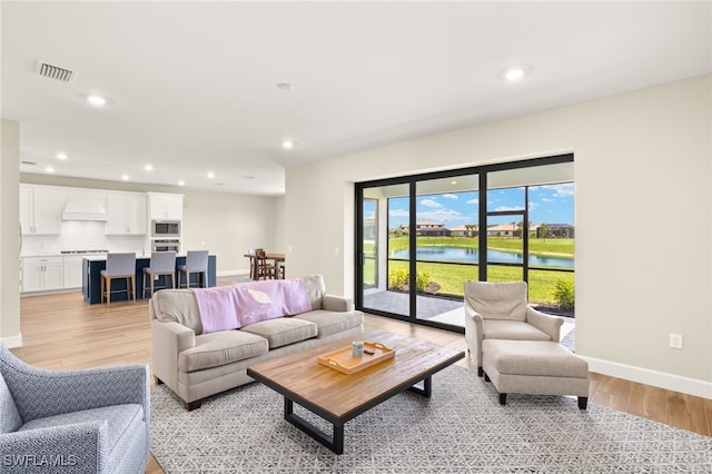 20676 Napa Loop, Estero, FL 33928 - living room with light wood finished floors, recessed lighting, and a water view