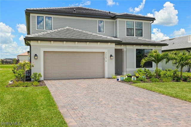 20676 Napa Loop, Estero, FL 33928 - view of front of home featuring decorative driveway, a garage, a front lawn, stucco siding, and a tile roof