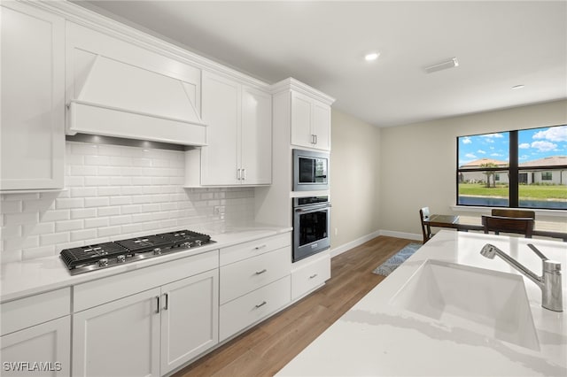20676 Napa Loop, Estero, FL 33928 - kitchen featuring stainless steel appliances, white cabinets, backsplash, wood finished floors, and light stone countertops