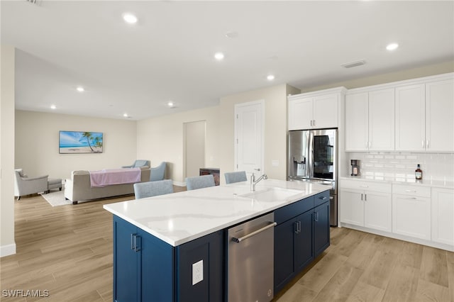 20676 Napa Loop, Estero, FL 33928 - kitchen featuring appliances with stainless steel finishes, light wood finished floors, white cabinetry, a center island with sink, and open floor plan