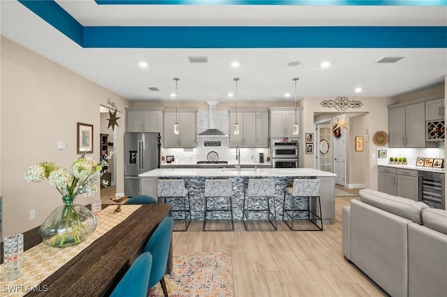 42274 Waterfront Way, Punta Gorda, FL 33982 - kitchen with wall chimney range hood, wine cooler, appliances with stainless steel finishes, gray cabinets, and recessed lighting