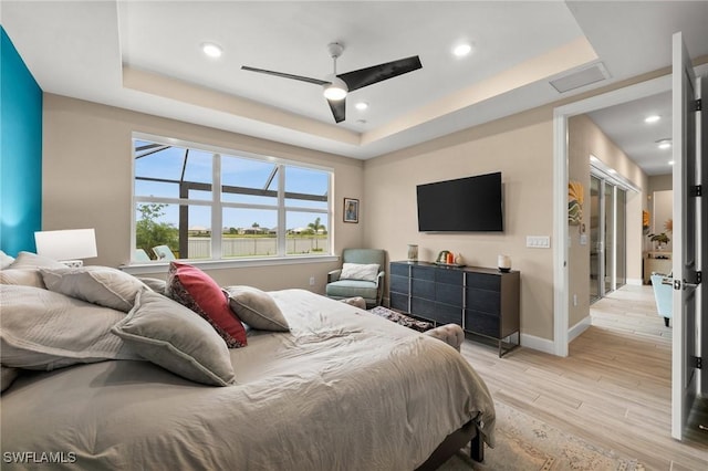 42274 Waterfront Way, Punta Gorda, FL 33982 - bedroom with a tray ceiling, light wood-type flooring, a ceiling fan, and recessed lighting