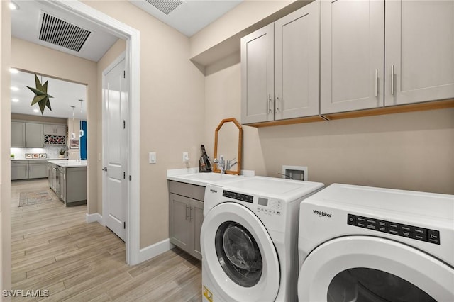 42274 Waterfront Way, Punta Gorda, FL 33982 - laundry room with separate washer and dryer, light wood-style flooring, and cabinet space