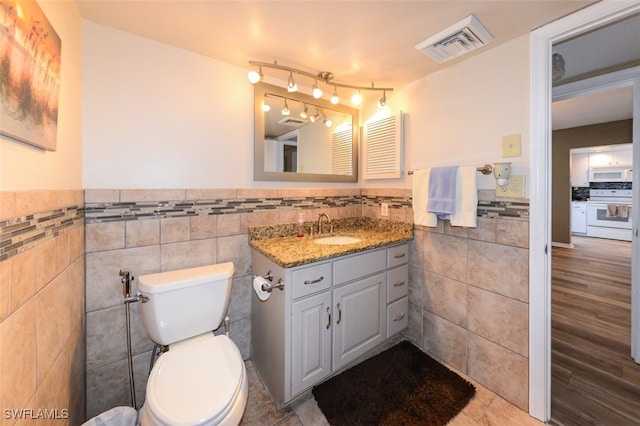 7000 Estero Blvd Unit 205, Fort Myers Beach, FL 33931 - bathroom with tile walls, vanity, wainscoting, and tile patterned floors