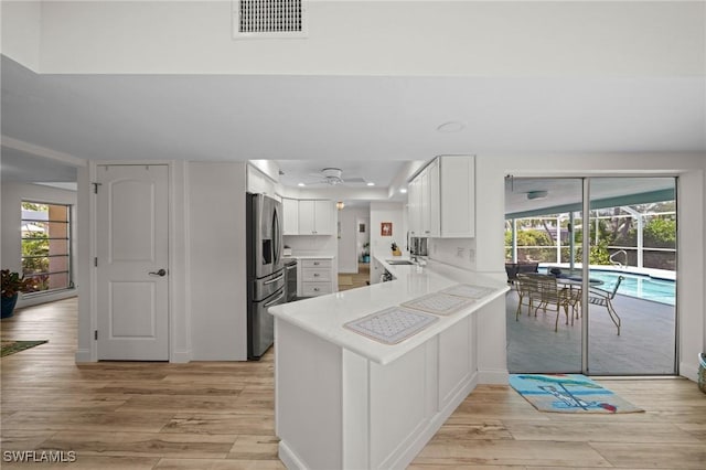 5301 SW 8th Pl, Cape Coral, FL 33914 - kitchen featuring a peninsula, light wood finished floors, stainless steel fridge with ice dispenser, a ceiling fan, and light countertops