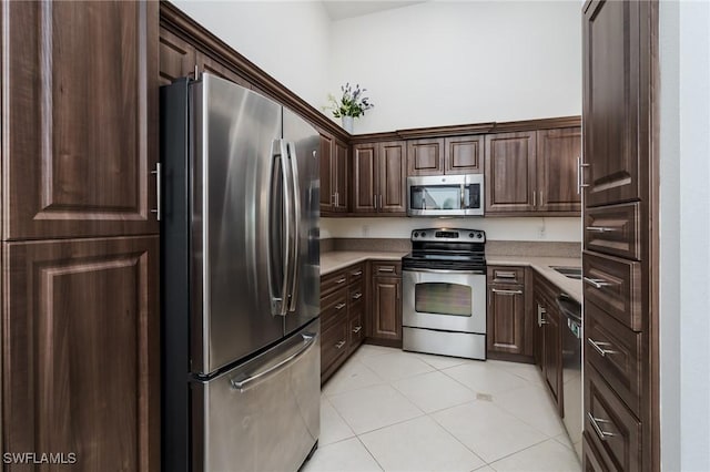 2525 Aspen Creek Ln Unit 202, Naples, FL 34119 - kitchen featuring stainless steel appliances, light countertops, dark brown cabinets, and light tile patterned floors
