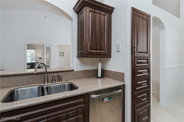 2525 Aspen Creek Ln Unit 202, Naples, FL 34119 - kitchen with stainless steel dishwasher, arched walkways, dark brown cabinetry, and light tile patterned flooring