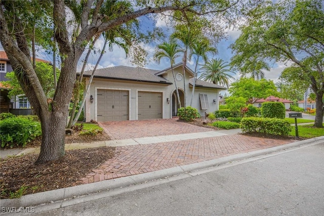 6912 Anthurium Ln, Naples, FL 34113 - view of front facade with stucco siding, an attached garage, and decorative driveway