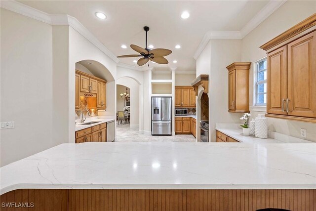 6912 Anthurium Ln, Naples, FL 34113 - kitchen with stainless steel appliances, arched walkways, crown molding, ceiling fan, and recessed lighting