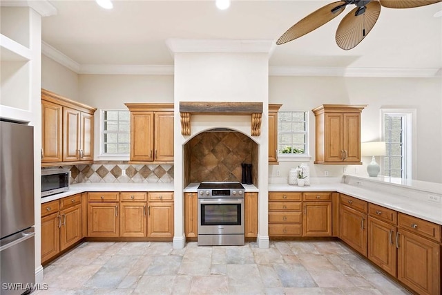 6912 Anthurium Ln, Naples, FL 34113 - kitchen featuring appliances with stainless steel finishes, a ceiling fan, light countertops, decorative backsplash, and ornamental molding