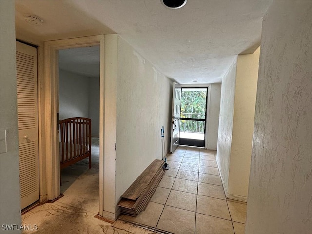 1224 Commonwealth Cir Unit N-203, Naples, FL 34116 - hallway with a textured wall, an upstairs landing, and light tile patterned floors