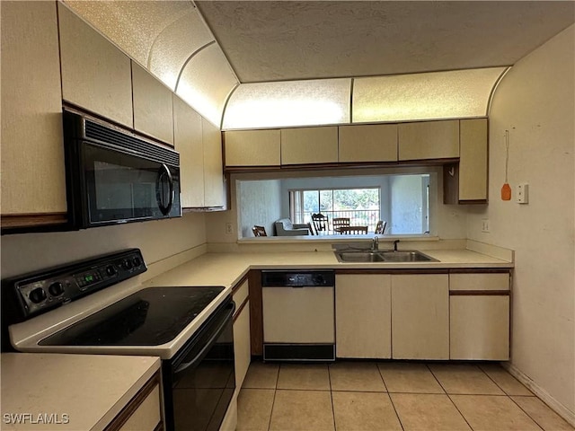 1224 Commonwealth Cir Unit N-203, Naples, FL 34116 - kitchen with black appliances, light tile patterned floors, light countertops, and cream cabinets