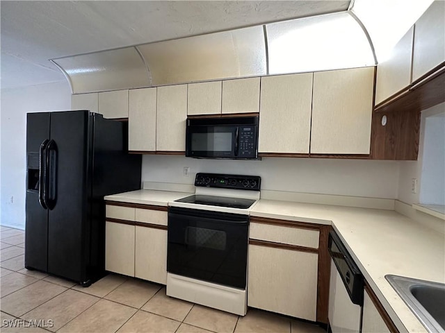 1224 Commonwealth Cir Unit N-203, Naples, FL 34116 - kitchen featuring black appliances, light countertops, and light tile patterned floors