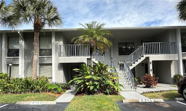 1224 Commonwealth Cir Unit N-203, Naples, FL 34116 - view of property featuring stairs and uncovered parking