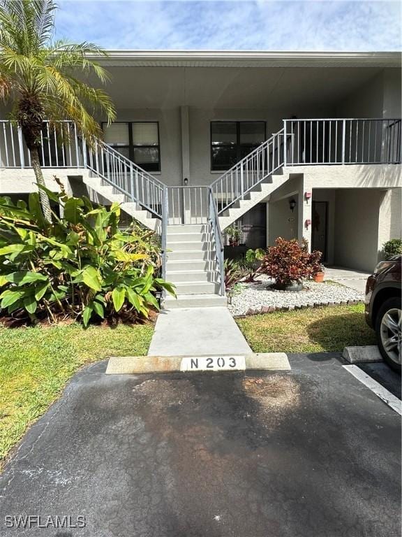 1224 Commonwealth Cir Unit N-203, Naples, FL 34116 - view of property featuring stairway and uncovered parking