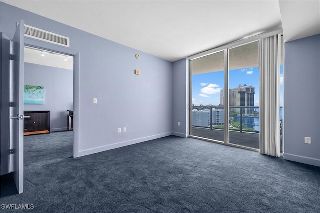 3000 Oasis Grand Blvd Unit 906, Fort Myers, FL 33916 - unfurnished room with dark colored carpet, a wall of windows, and a city view