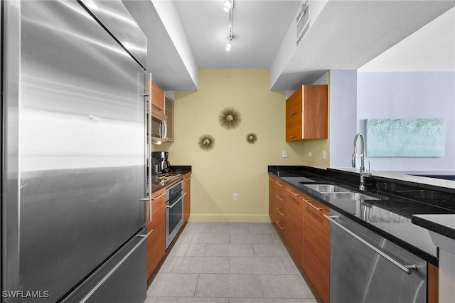 3000 Oasis Grand Blvd Unit 906, Fort Myers, FL 33916 - kitchen with appliances with stainless steel finishes, brown cabinets, modern cabinets, light tile patterned floors, and dark stone counters