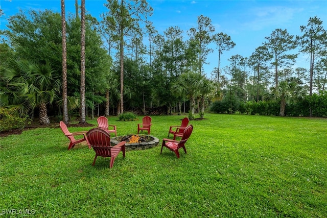 4345 6th Ave NE, Naples, FL 34120 - view of green lawn featuring a fire pit and view of wooded area