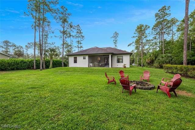 4345 6th Ave NE, Naples, FL 34120 - back of house with a fire pit, a yard, and stucco siding