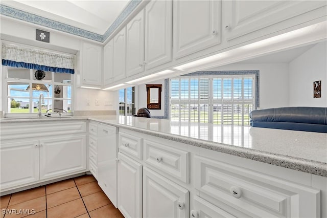 17770 Pineapple Palm Ct, North Fort Myers, FL 33917 - kitchen featuring light tile patterned floors, white cabinets, white dishwasher, and light stone counters