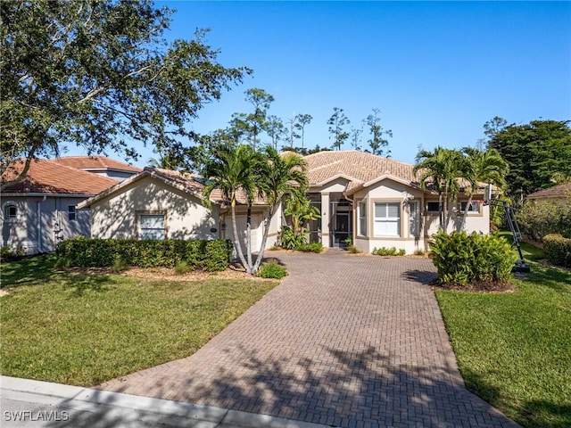 20838 Torre Del Lago St, Estero, FL 33928 - view of front facade featuring decorative driveway, a garage, a tile roof, stucco siding, and a front yard