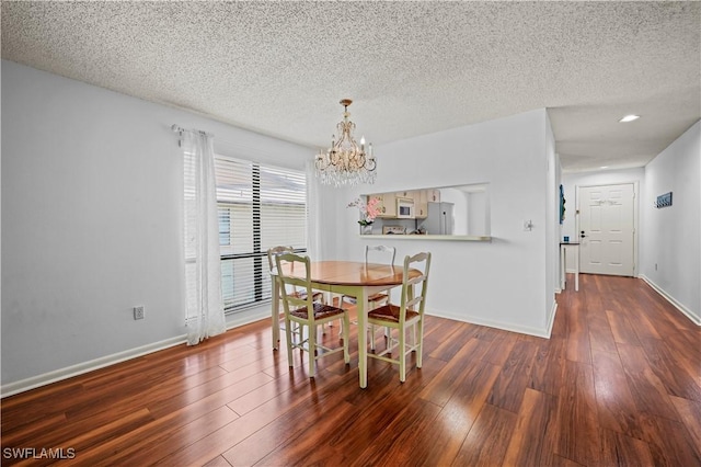 240 Pebble Beach Cir Unit F206, Naples, FL 34113 - dining space featuring a chandelier, wood finished floors, and a textured ceiling