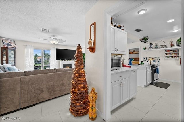 4251 Island Cir Unit 3, Fort Myers, FL 33919 - kitchen featuring stainless steel electric range oven, a ceiling fan, open floor plan, white cabinets, and light tile patterned flooring