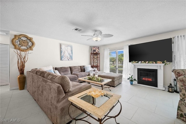 4251 Island Cir Unit 3, Fort Myers, FL 33919 - living room with a textured ceiling, a glass covered fireplace, a ceiling fan, and light tile patterned floors
