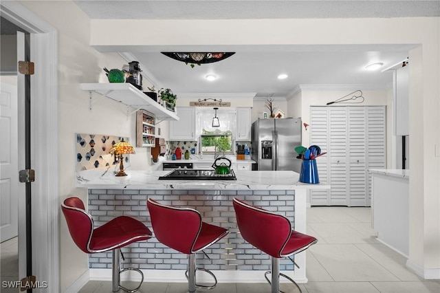 4251 Island Cir Unit 3, Fort Myers, FL 33919 - kitchen featuring stainless steel refrigerator with ice dispenser, a peninsula, white cabinetry, black electric cooktop, and light tile patterned floors