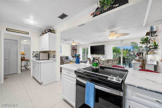 4251 Island Cir Unit 3, Fort Myers, FL 33919 - kitchen featuring electric stove, white microwave, ceiling fan, white cabinetry, and light tile patterned flooring