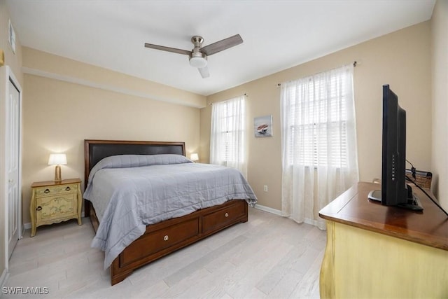 12970 Positano Cir Unit 301, Naples, FL 34105 - bedroom with light wood-type flooring and a ceiling fan