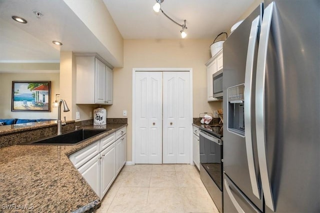 12970 Positano Cir Unit 301, Naples, FL 34105 - kitchen with appliances with stainless steel finishes, light tile patterned flooring, white cabinetry, and dark stone counters
