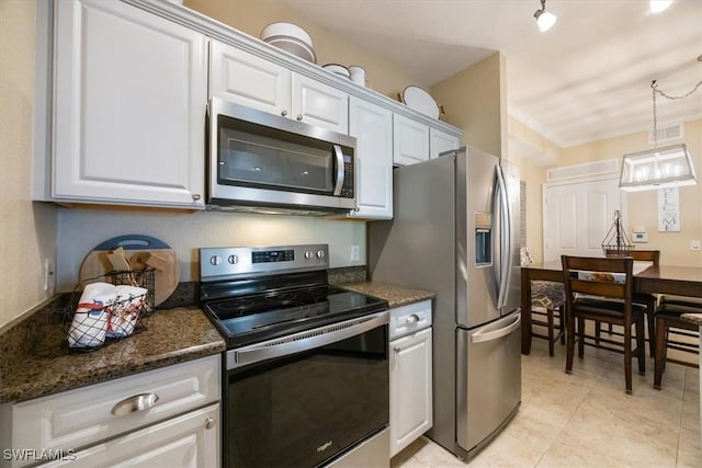 12970 Positano Cir Unit 301, Naples, FL 34105 - kitchen featuring appliances with stainless steel finishes, white cabinetry, hanging light fixtures, and light tile patterned floors
