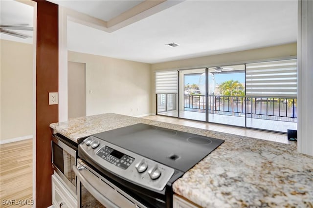 4210 SE 20th Pl Unit C2, Cape Coral, FL 33904 - kitchen with appliances with stainless steel finishes, light wood-style floors, a ceiling fan, and light stone countertops