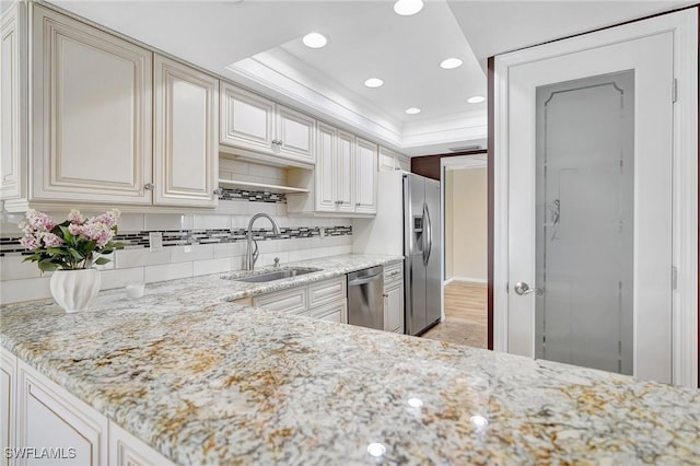 4210 SE 20th Pl Unit C2, Cape Coral, FL 33904 - kitchen with appliances with stainless steel finishes, a raised ceiling, tasteful backsplash, recessed lighting, and light stone counters