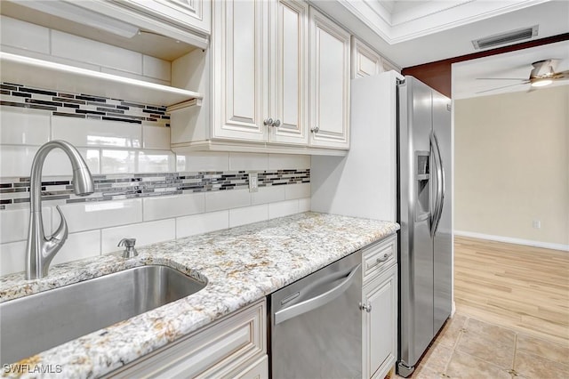 4210 SE 20th Pl Unit C2, Cape Coral, FL 33904 - kitchen with stainless steel dishwasher, decorative backsplash, light stone countertops, ceiling fan, and white cabinetry