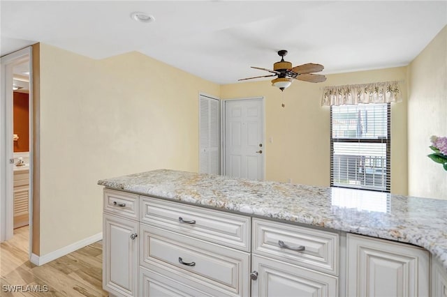 4210 SE 20th Pl Unit C2, Cape Coral, FL 33904 - kitchen with ceiling fan, light wood-type flooring, white cabinetry, and light stone counters